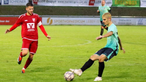 Zwei Fußballspieler während dem Spiel mit dem Fußball auf dem Rasen