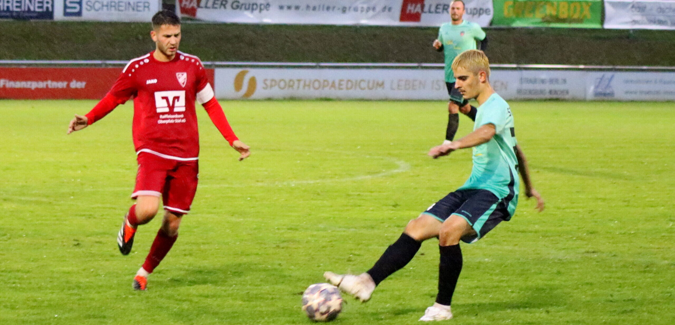 Zwei Fußballspieler während dem Spiel mit dem Fußball auf dem Rasen